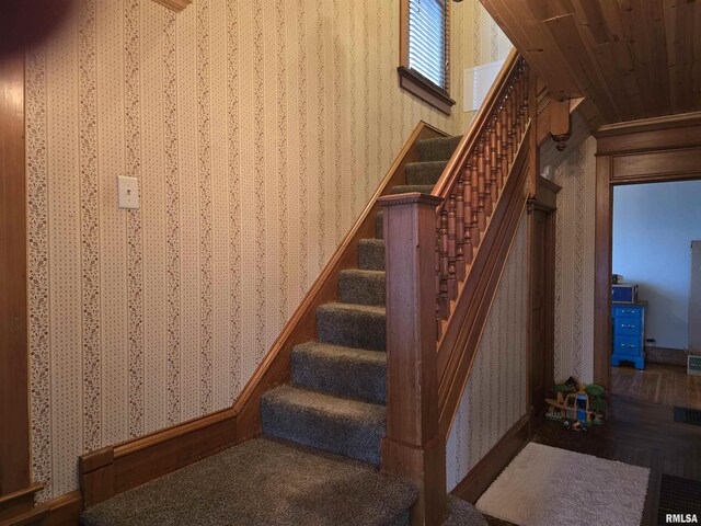 stairs featuring wallpapered walls