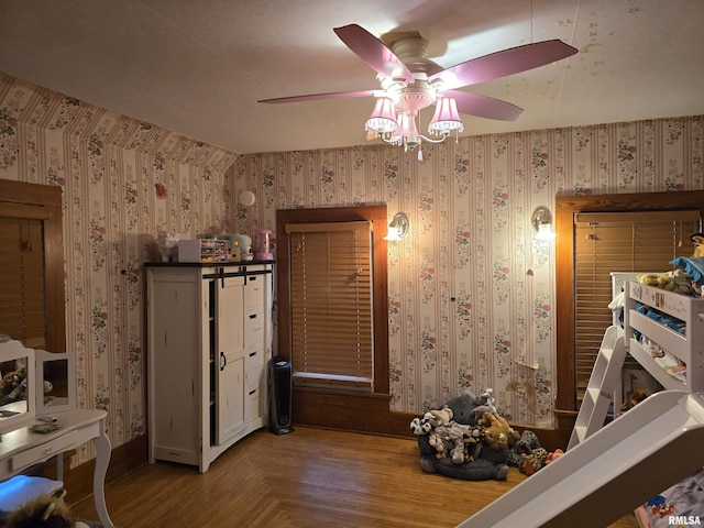 bedroom with a ceiling fan, parquet floors, and wallpapered walls