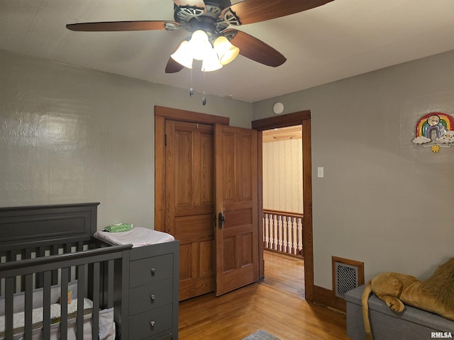 bedroom featuring a closet, visible vents, a ceiling fan, light wood-type flooring, and baseboards