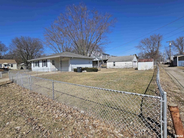 view of front facade featuring a storage shed, fence private yard, a front lawn, and an outdoor structure