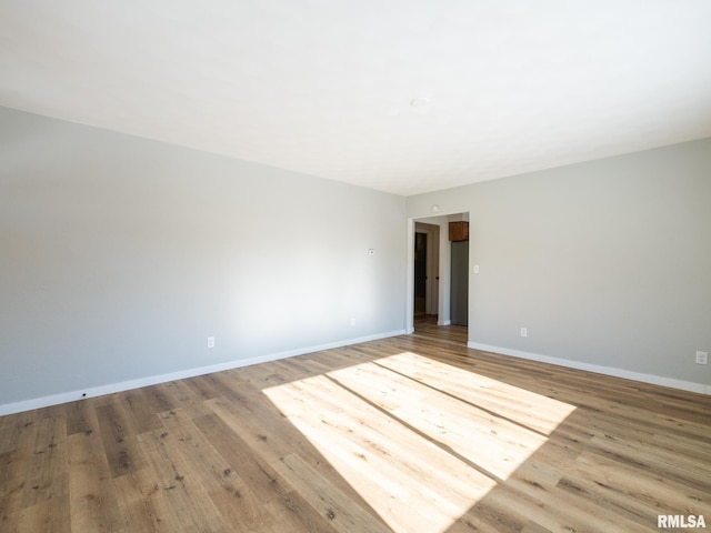 unfurnished room featuring wood finished floors and baseboards