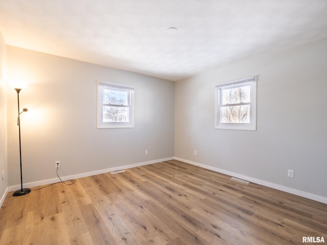 empty room featuring light wood-style flooring and baseboards