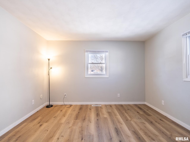 unfurnished room with baseboards and light wood-type flooring