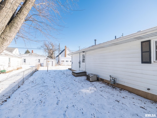 snowy yard with a residential view and fence