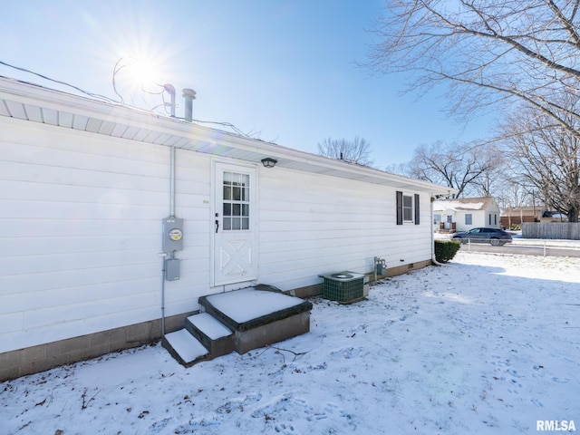 snow covered house with central air condition unit