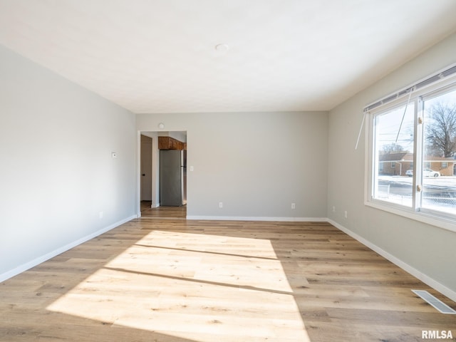 spare room with visible vents, baseboards, and light wood-style floors