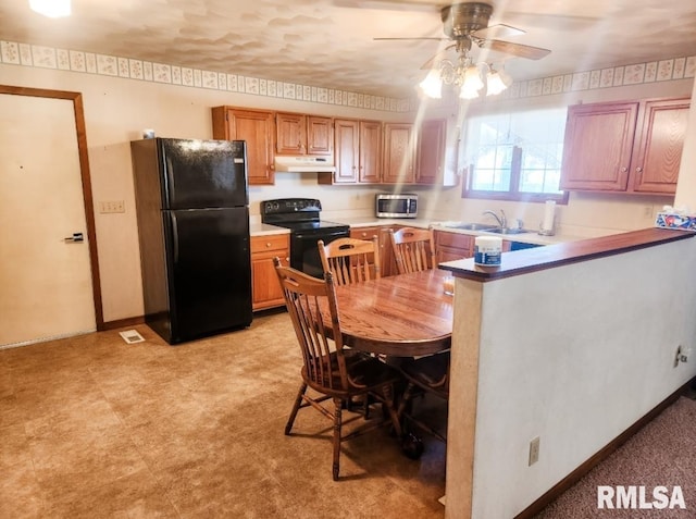 kitchen with visible vents, a sink, a peninsula, under cabinet range hood, and black appliances