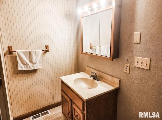 bathroom featuring baseboards, visible vents, and vanity