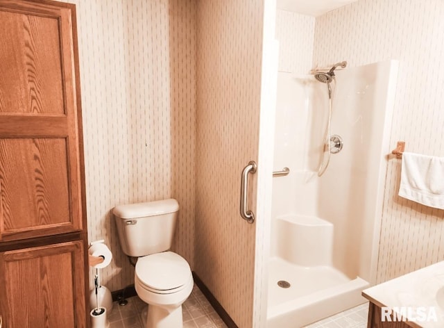 bathroom with a walk in shower, vanity, toilet, and wallpapered walls