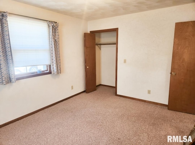 unfurnished bedroom with baseboards, a closet, and light colored carpet