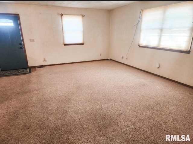 carpeted spare room featuring baseboards