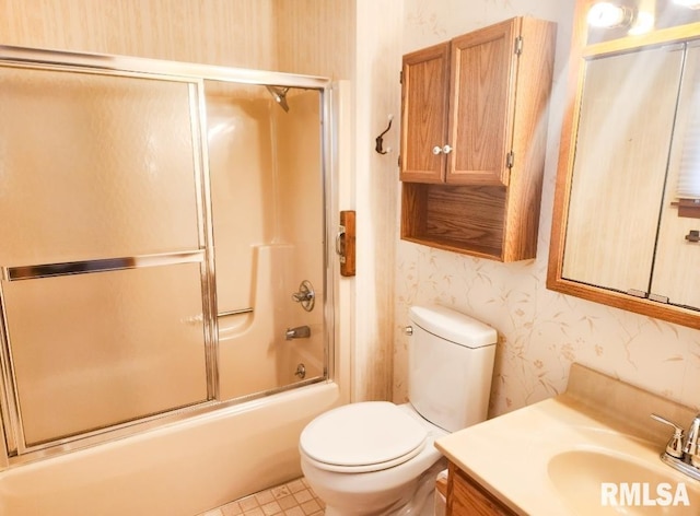 bathroom with toilet, wallpapered walls, shower / bath combination with glass door, and vanity