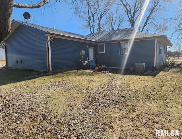 rear view of property featuring a yard and central AC unit