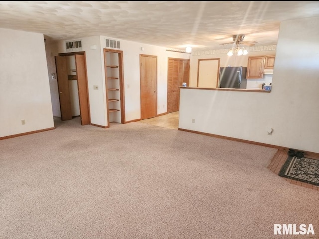 unfurnished living room featuring light carpet, visible vents, and a textured ceiling