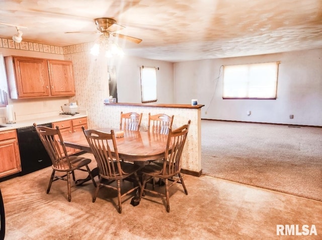 dining area featuring light carpet, plenty of natural light, baseboards, and ceiling fan