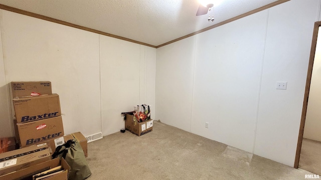 carpeted empty room with a textured ceiling and crown molding