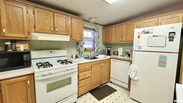 kitchen featuring light countertops, white appliances, under cabinet range hood, a sink, and light floors