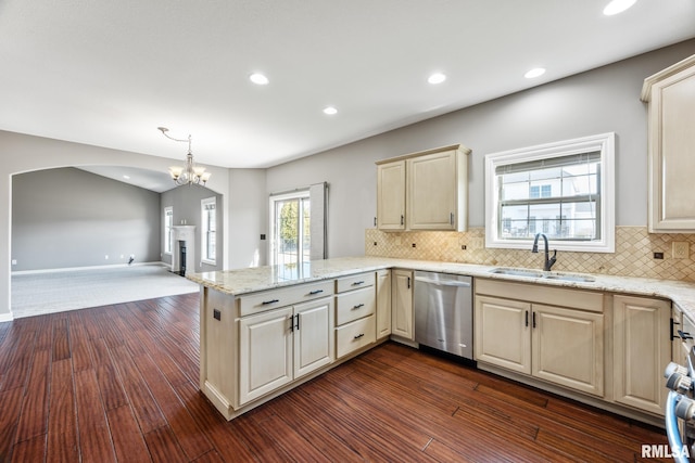 kitchen with a peninsula, a sink, dark wood-type flooring, dishwasher, and open floor plan