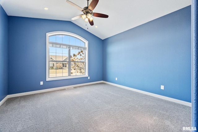 carpeted spare room with lofted ceiling, visible vents, baseboards, and ceiling fan