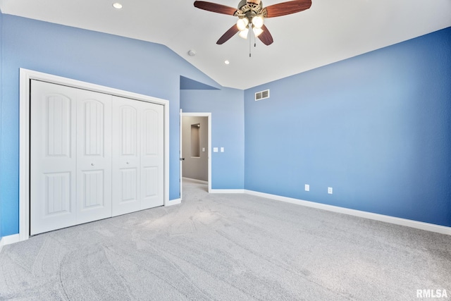 unfurnished bedroom featuring visible vents, baseboards, vaulted ceiling, carpet flooring, and a closet