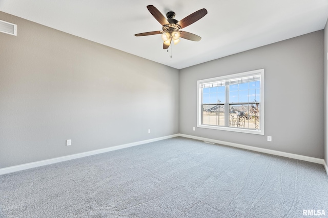 carpeted empty room with visible vents, baseboards, and ceiling fan