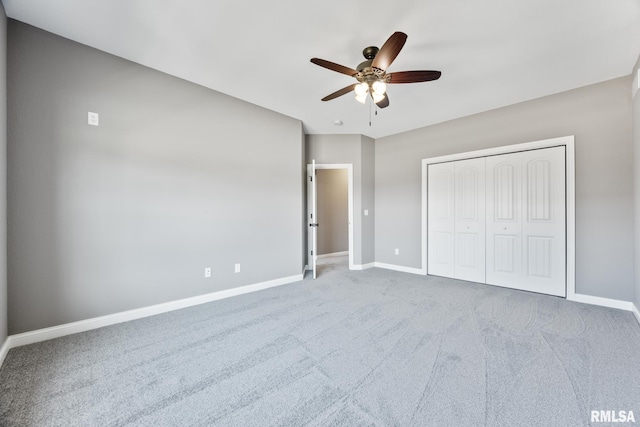 unfurnished bedroom with a closet, ceiling fan, carpet, and baseboards