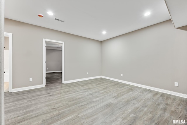 spare room with visible vents, recessed lighting, wood finished floors, and baseboards