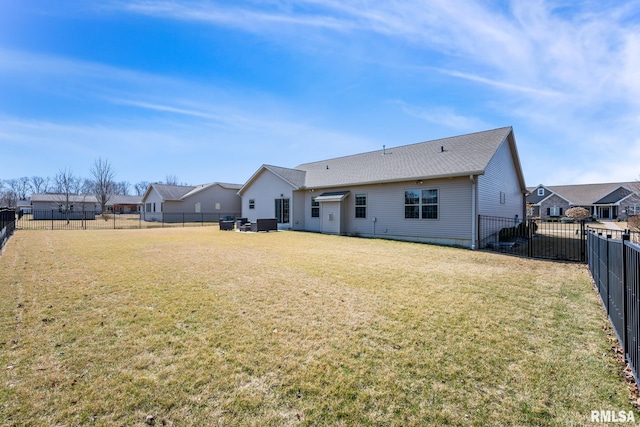 back of property featuring a yard and a fenced backyard