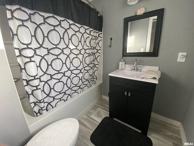 bathroom with shower / bath combo, vanity, baseboards, and wood finished floors