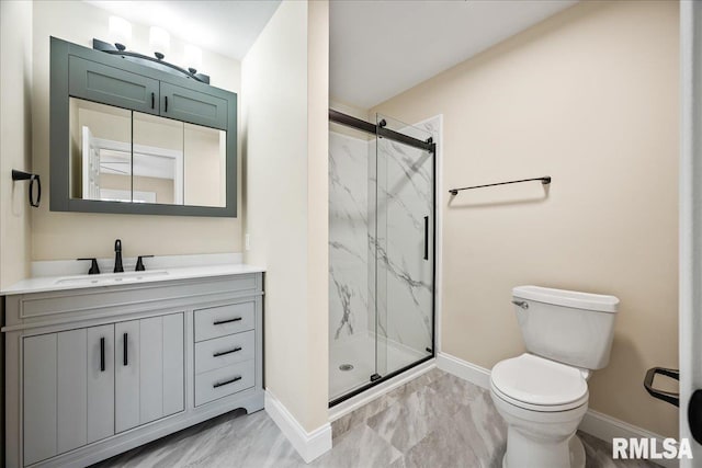 bathroom with baseboards, toilet, vanity, and a marble finish shower