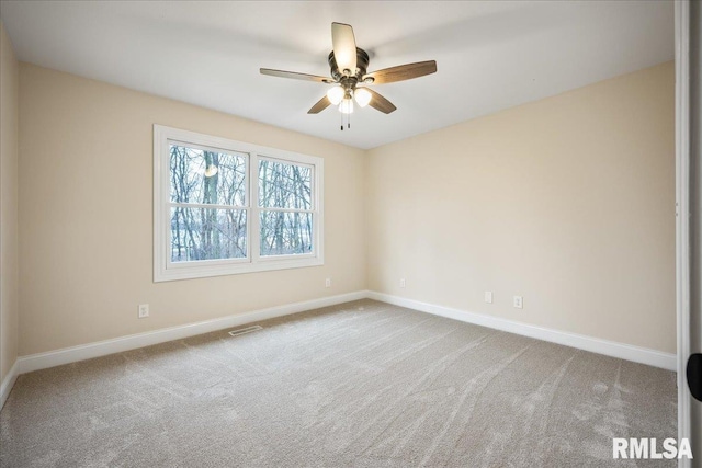 carpeted empty room featuring visible vents, ceiling fan, and baseboards