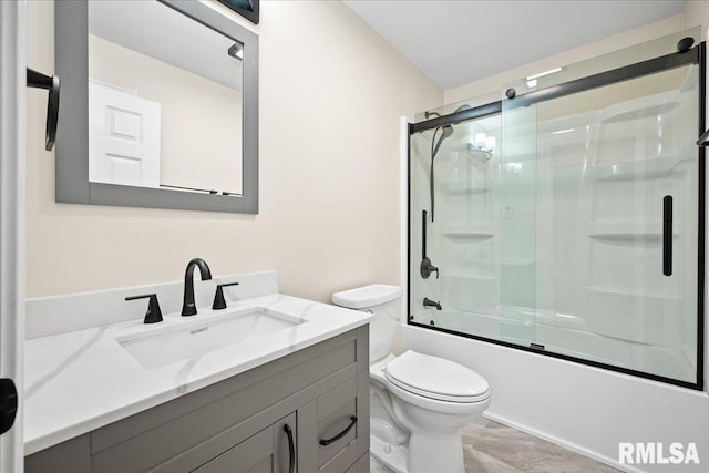 bathroom featuring toilet, enclosed tub / shower combo, and vanity