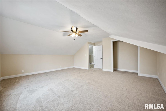 additional living space featuring carpet, a ceiling fan, vaulted ceiling, a textured ceiling, and baseboards