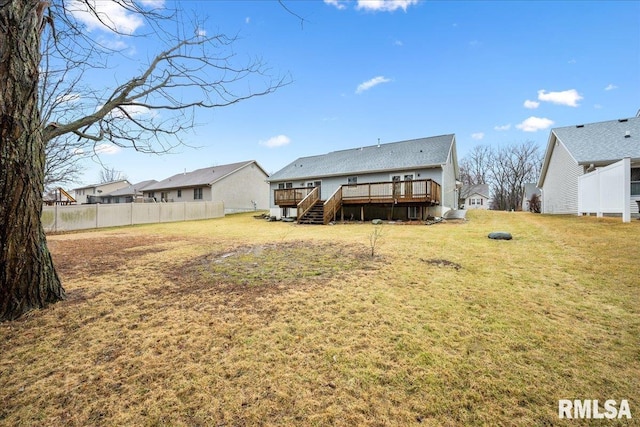 rear view of house with a yard, fence, and a deck