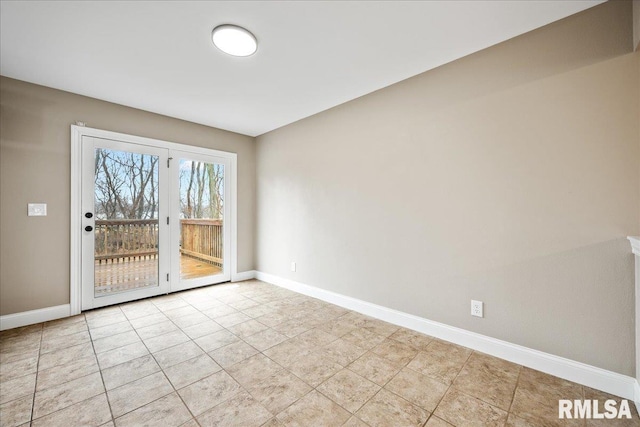 spare room featuring baseboards and light tile patterned floors