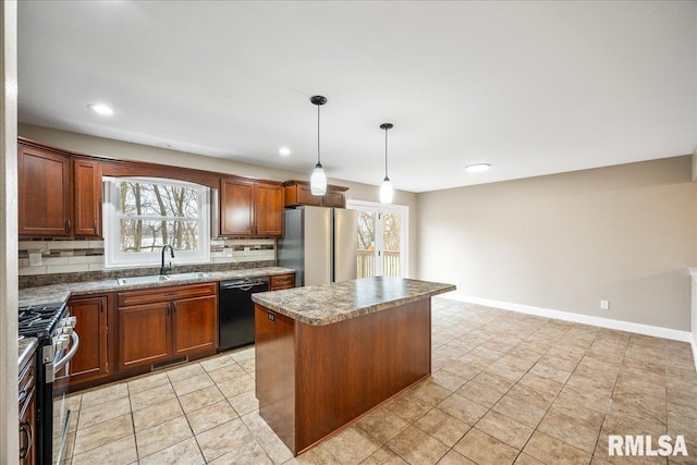 kitchen with visible vents, decorative backsplash, a kitchen island, appliances with stainless steel finishes, and a sink