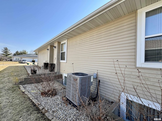 view of property exterior featuring central air condition unit and a yard