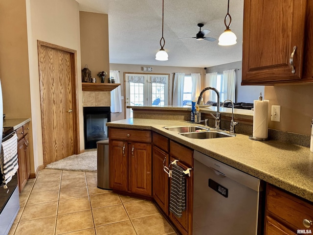 kitchen with light tile patterned floors, hanging light fixtures, stainless steel dishwasher, a sink, and range with electric stovetop