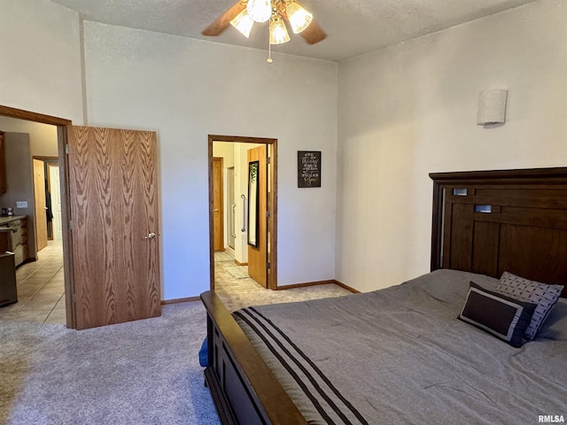 bedroom with a ceiling fan, a high ceiling, light carpet, and baseboards