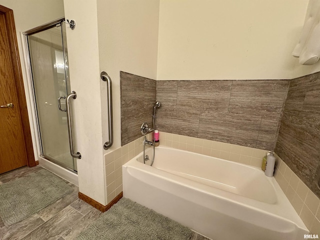 bathroom with a shower stall and a bath