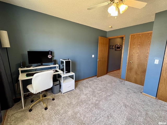 carpeted office with ceiling fan, baseboards, and a textured ceiling