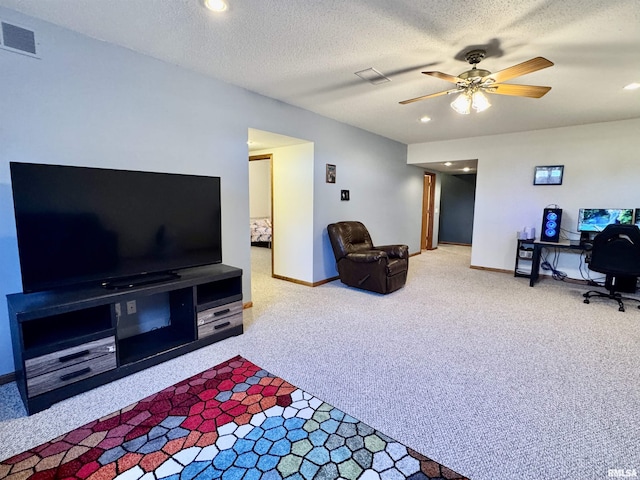 living area with a ceiling fan, carpet, visible vents, and a textured ceiling