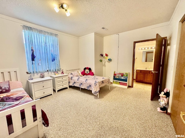 bedroom featuring light carpet, visible vents, a textured ceiling, and ensuite bathroom