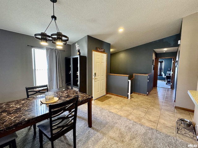 dining room featuring light tile patterned floors, a textured ceiling, a chandelier, baseboards, and vaulted ceiling