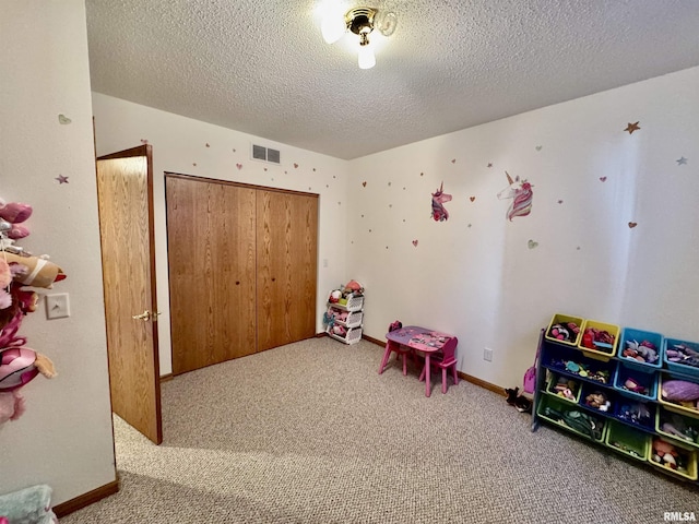 recreation room featuring carpet floors, baseboards, visible vents, and a textured ceiling