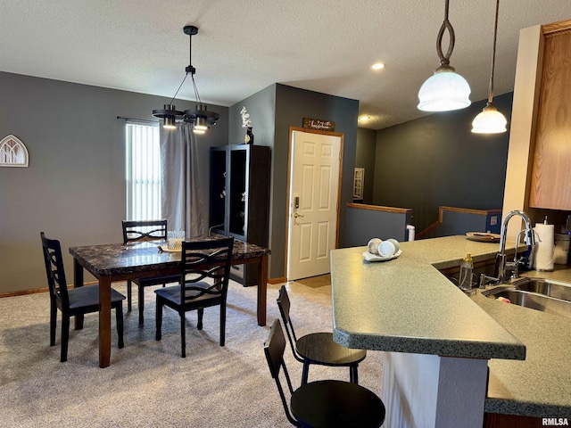 dining room featuring light carpet, baseboards, and a textured ceiling