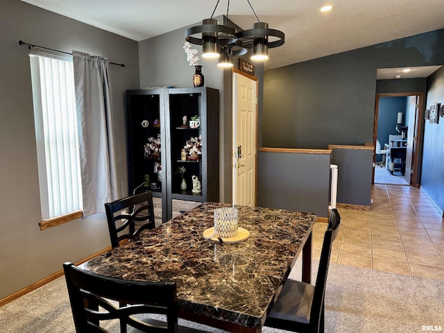 dining area featuring lofted ceiling, light tile patterned floors, and light colored carpet