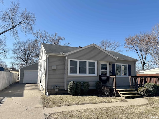 view of front of property with an outdoor structure, fence, a detached garage, and roof with shingles