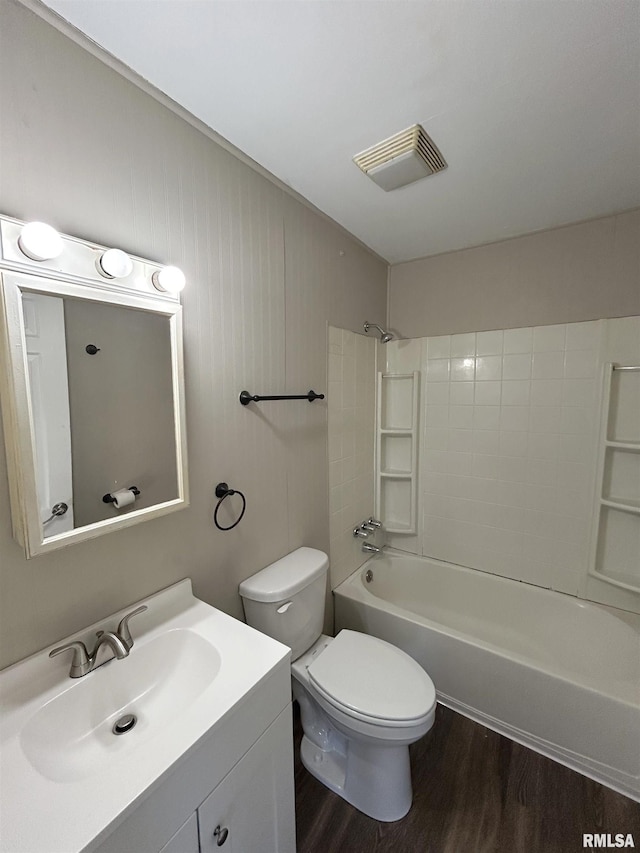 bathroom featuring visible vents, toilet, shower / bath combination, wood finished floors, and vanity