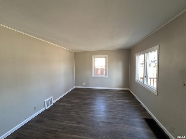 unfurnished room with dark wood-type flooring, baseboards, and ornamental molding